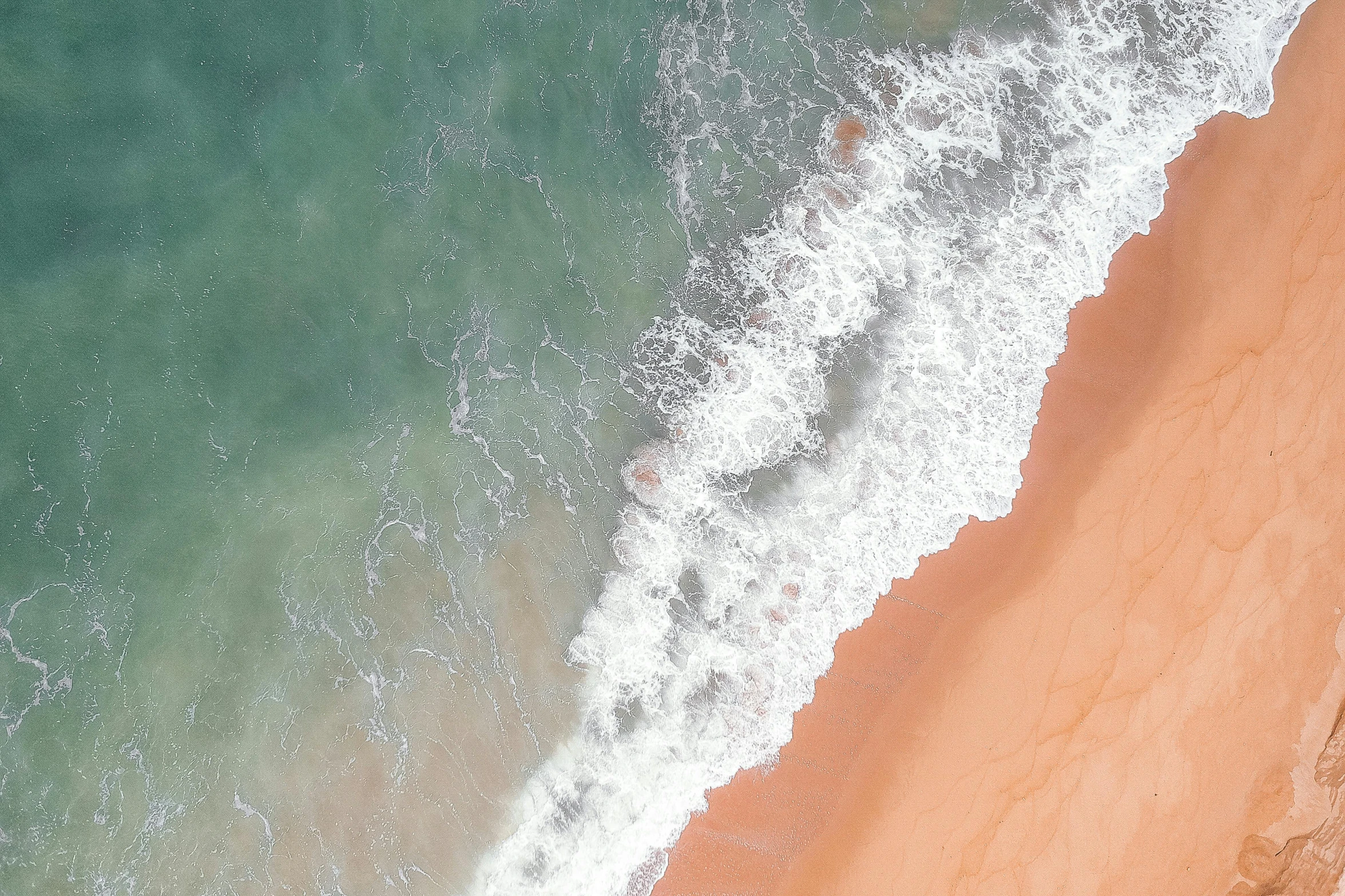 a person riding a surfboard on top of a sandy beach, pexels contest winner, minimalism, flowing salmon-colored silk, helicopter view, cresting waves and seafoam, iphone wallpaper