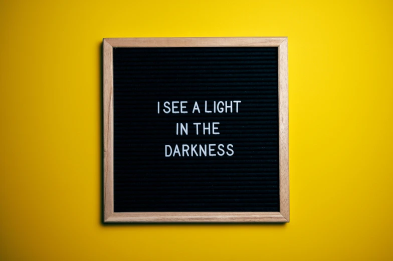 a sign that says i see a light in the darkness, inspired by Carrie Mae Weems, unsplash contest winner, panel of black, yellowish light, mundane, instagram post