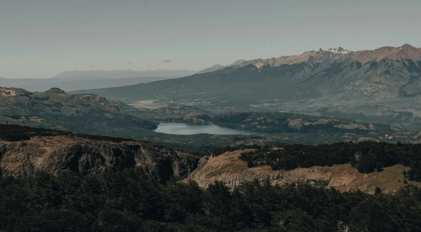 a couple of people standing on top of a mountain, a matte painting, by Matteo Pérez, pexels contest winner, lake in the distance, distant shot birds eye view, andes mountain forest, gif