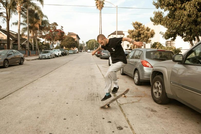 a man riding a skateboard down the side of a street, a picture, kailee mandel, cement, in front of a garage, jordan lamarre - wan