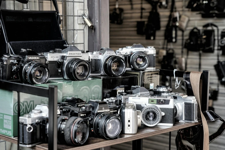 a bunch of cameras sitting on top of a table, a picture, looking at camera, street photography, antiques, medium format