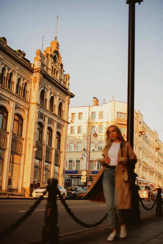 a woman walking down a street past tall buildings, russian architecture, at the golden hour, streetscapes, trending on