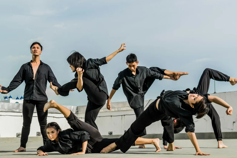 a group of people doing a handstand pose, a portrait, inspired by Baiōken Eishun, unsplash, gutai group, wearing black clothes, malaysian, fighting scene, avatar image