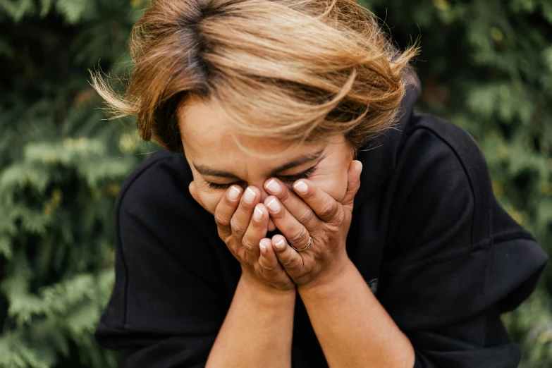 a woman covers her face with her hands, pexels contest winner, crying engine, manuka, recovering from pain, looking at the ground