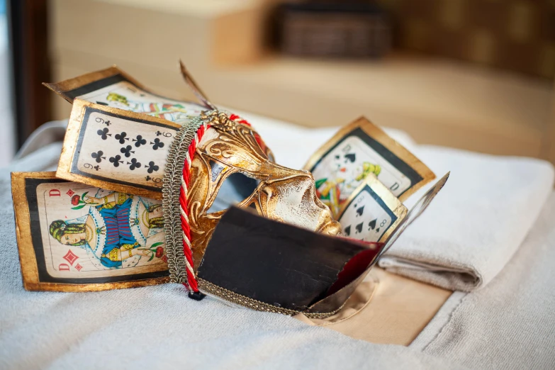 a box filled with cards sitting on top of a bed, a still life, unsplash, qajar art, ornate metal gold headpiece, gauntlets, elliot alderson, recreation