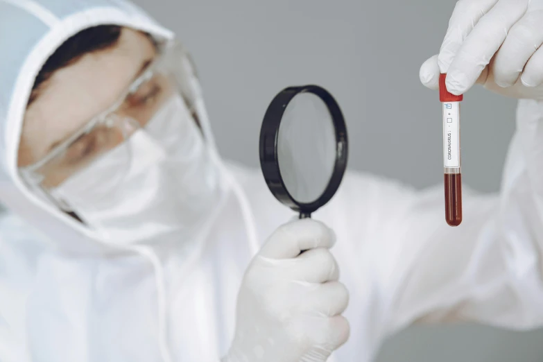 a person in a lab coat holding a magnifying glass, pexels contest winner, analytical art, white and blood color scheme, medical labels, blooded, staff wearing hazmat suits