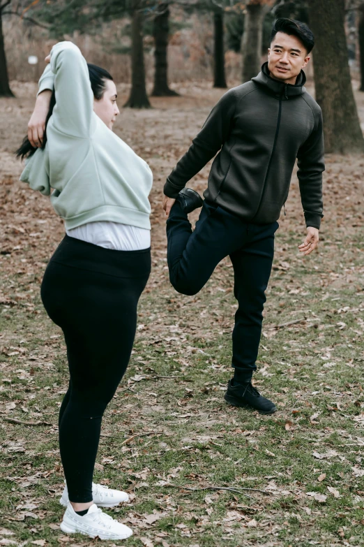 a man and a woman playing frisbee in a park, an album cover, unsplash, leggings, pregnant, low quality photo, thicc