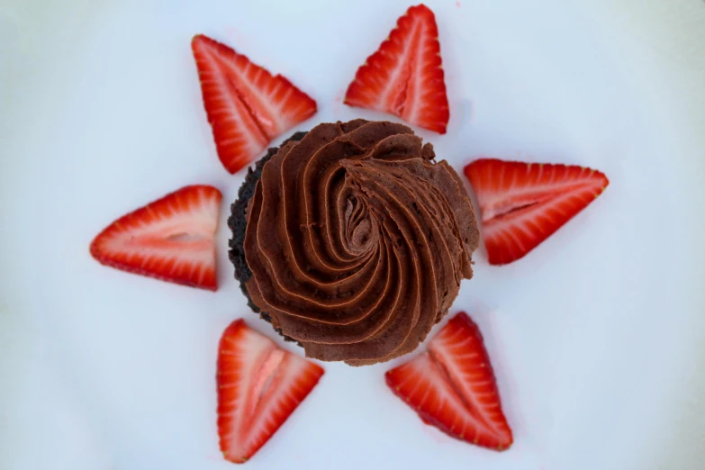 a chocolate cupcake topped with strawberries on a white plate, by Juliette Wytsman, pexels, top down photo at 45 degrees, lit from below, chocolate frosting, 🎀 🗡 🍓 🧚