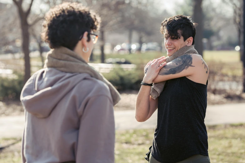 a man standing next to a woman in a park, happening, lgbtq, photograph of a sleeve tattoo, zachary corzine, press photos