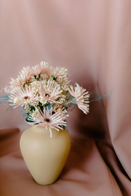 a yellow vase with some pink flowers in it, a still life, trending on unsplash, beige cream natural muted tones, flannel flower, fully covered, soft pink lights