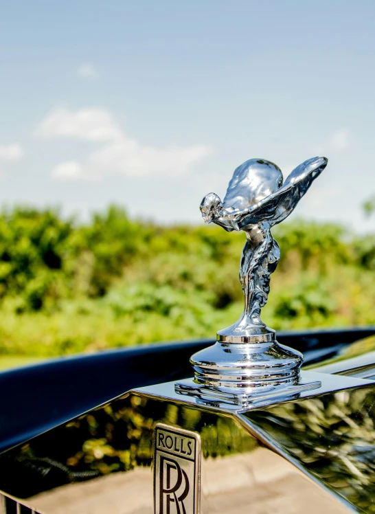 a close up of a hood ornament on a car, an art deco sculpture, by Sven Erixson, unsplash, happening, in a scenic background, waving robe movement, on display ”, high quality product image”