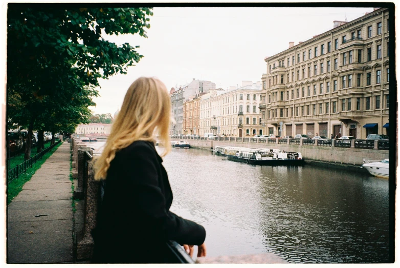 a woman standing next to a body of water, a picture, inspired by Anna Füssli, saint petersburg, medium format, people watching, a blond