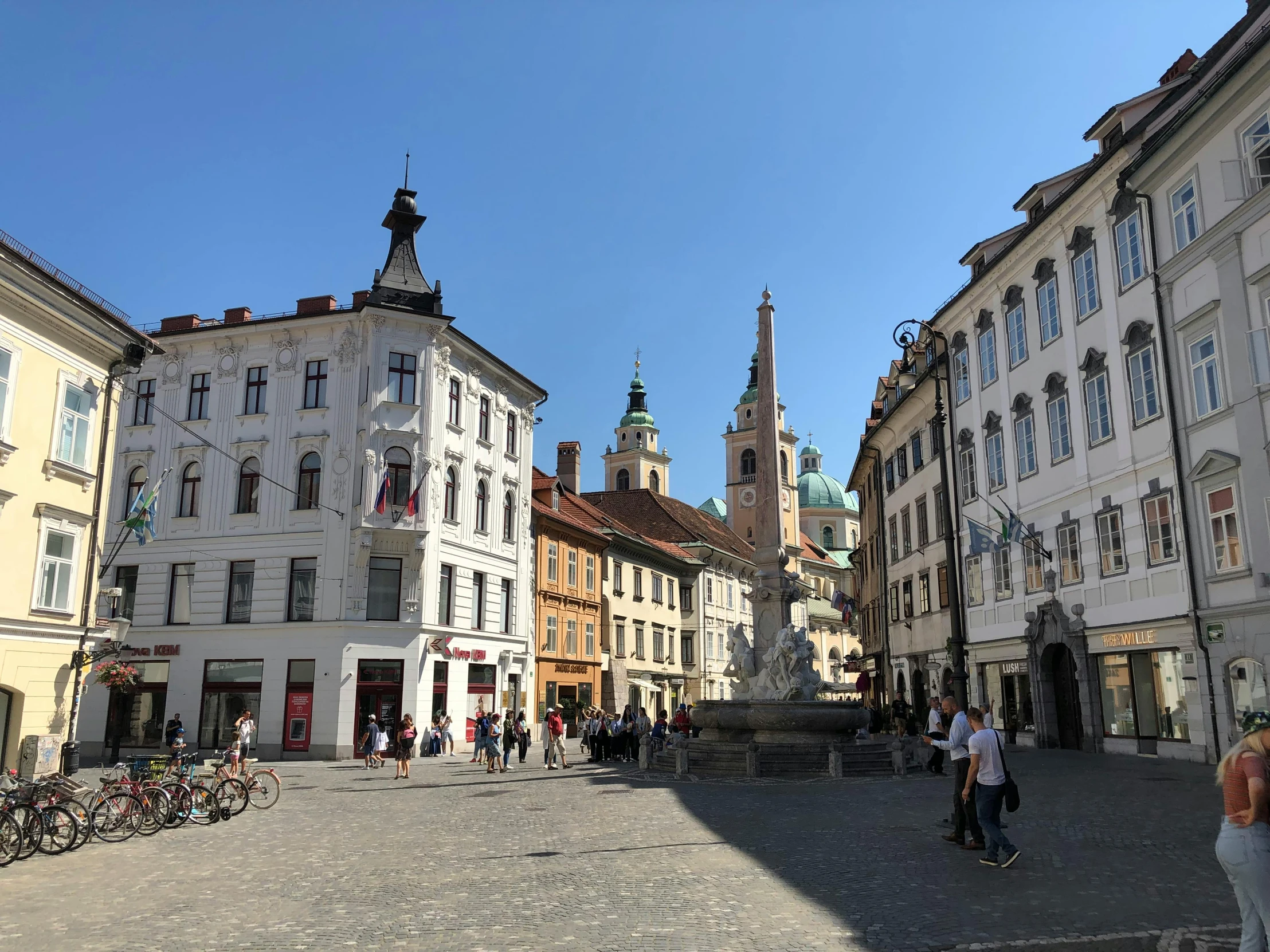 a group of people walking down a street next to tall buildings, baroque, town square, sunken square, austrian architecture, profile image