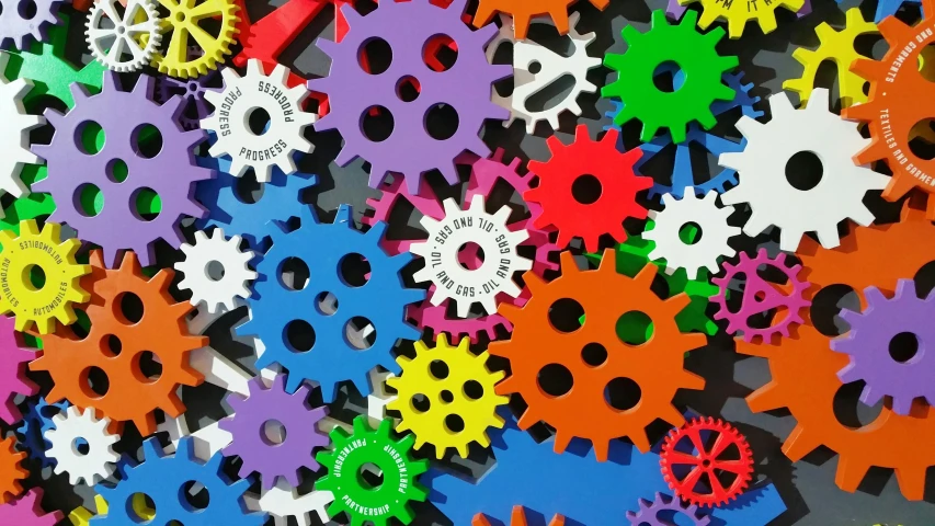 a bunch of colorful gears sitting on top of a table, large patches of plain colours, spiky, profile pic, mechanical vehicles