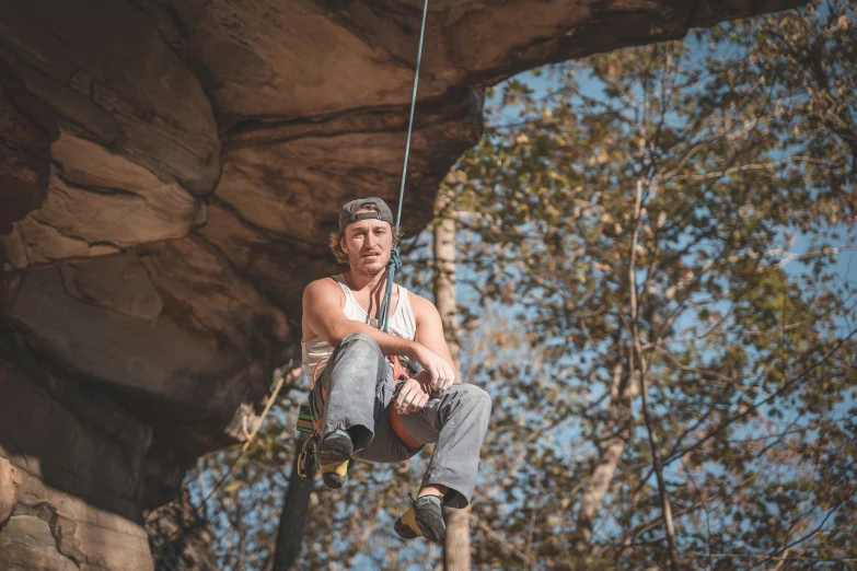 a man on a rock climbing on a rope, a portrait, by Lee Loughridge, pexels contest winner, sitting in a tree, avatar image, sydney hanson, lane brown