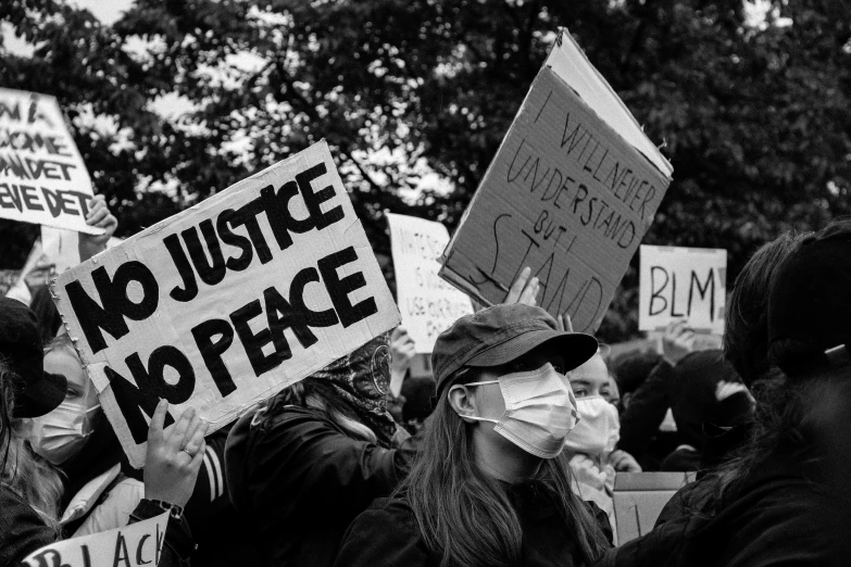 a group of people holding signs at a protest, a black and white photo, by Matija Jama, pexels, renaissance, world peace, homicide, photo still of, justice