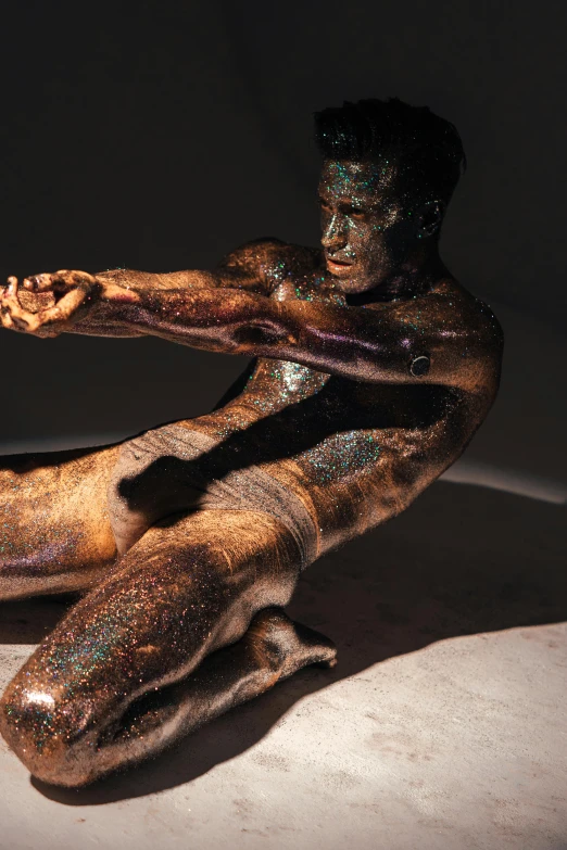 a man that has some paint on his body, a bronze sculpture, iridescent skin, brown skin like soil, promo image, slide show