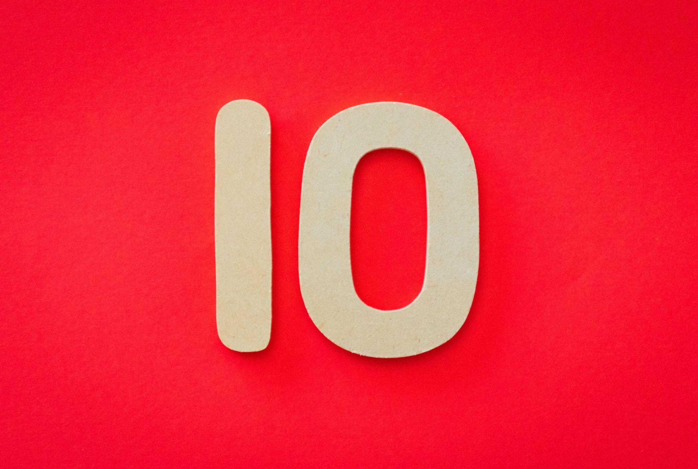 a wooden number ten on a red background, by Rachel Reckitt, trending on unsplash, letterism, hoses:10, 10 mm, no - text no - logo, iq 4
