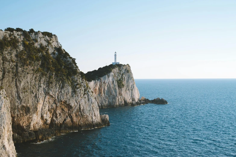 a lighthouse sitting on top of a cliff next to the ocean, pexels contest winner, renaissance, capri coast, abel tasman, slightly minimal, “ aerial view of a mountain