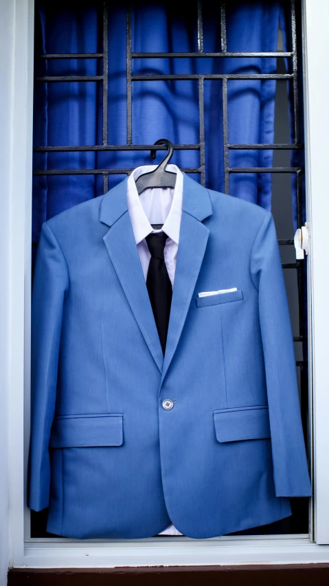 a blue suit is hanging in a window, by Carey Morris, pexels, pee wee herman, photograph credit: ap, blue colored, blue door
