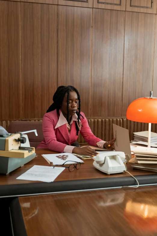 a woman sitting at a desk talking on a phone, an album cover, 4k movie still, adebanji alade, librarian, high-res