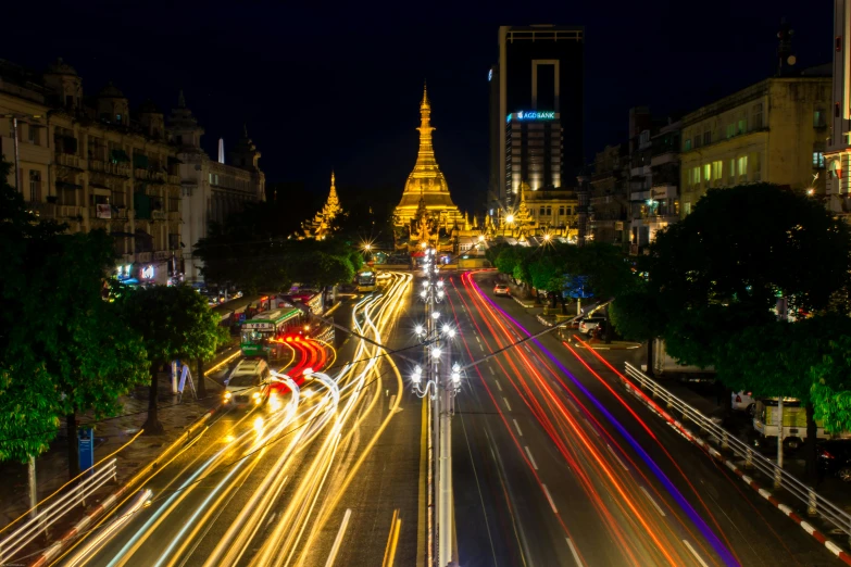 a street filled with lots of traffic next to tall buildings, unsplash contest winner, myanmar, lines of lights, majestic spires, thumbnail