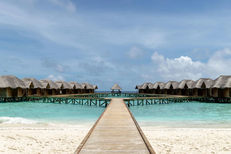 a wooden walkway leading to a beach with thatched huts, pexels contest winner, hurufiyya, clear blue water, conor walton, sol retreat, profile image