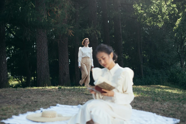 a woman sitting on a blanket reading a book, inspired by Béni Ferenczy, pexels contest winner, renaissance, wearing white suit, two models in the frame, girl walking in forest, korean woman