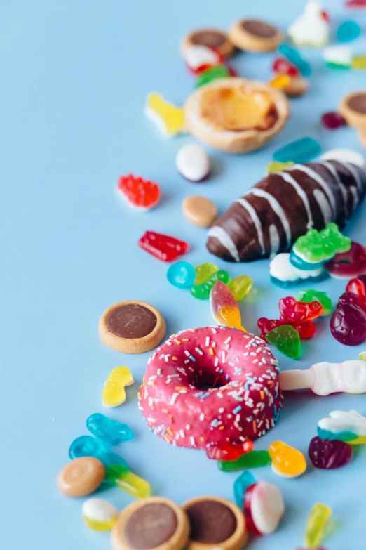 a table topped with lots of different types of candies, a still life, by Julia Pishtar, trending on pexels, blender donut, sky blue, colourful close up shot, flatlay