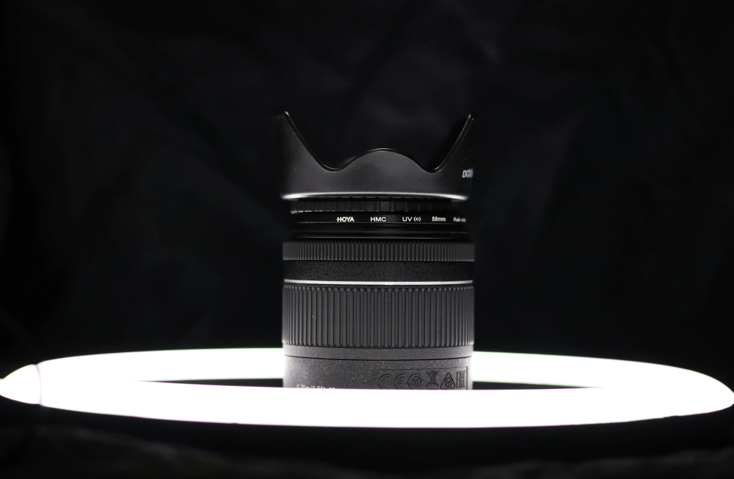 a close up of a camera lens on a table, in front of a black background, set against a white background, shot with sigma f/ 4.2, 12mm wide-angle