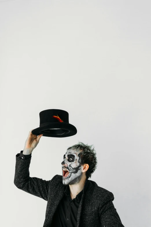 a man dressed as a skeleton with a top hat, inspired by Jodorowsky, pexels contest winner, a photo of a disheveled man, plain background, facepaint, clown