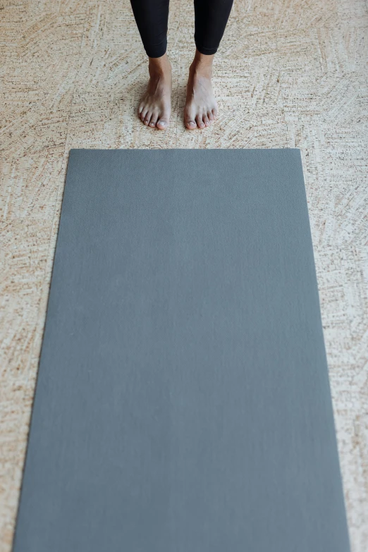 a woman standing on a yoga mat on the floor, by David Simpson, unsplash, conceptual art, flat grey color, high texture detail, linen canvas, 165 cm tall
