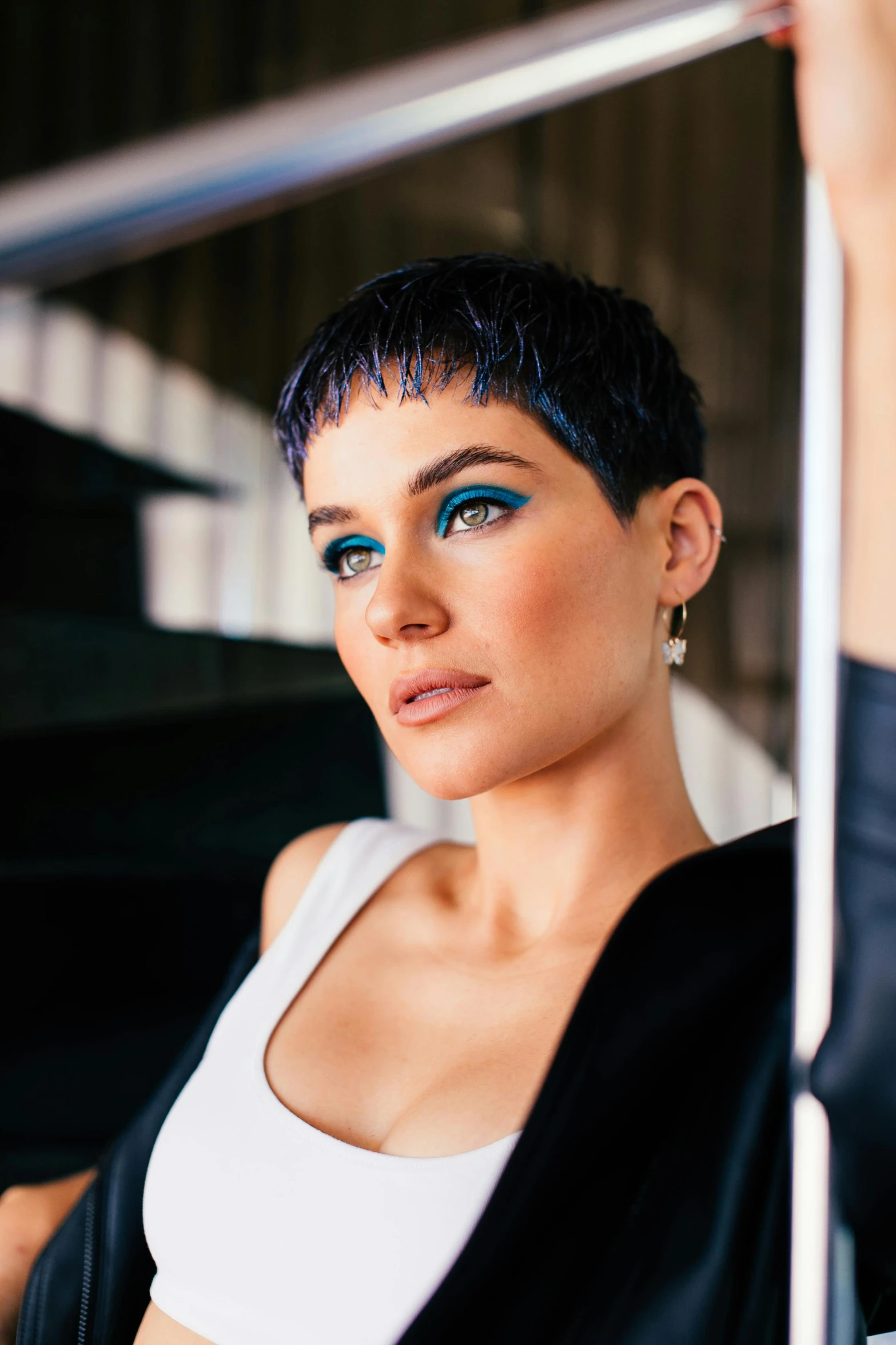 a close up of a person holding a pole, an album cover, by Julia Pishtar, short black pixie cut hair, blue lipstick, olivia culpo, profile image