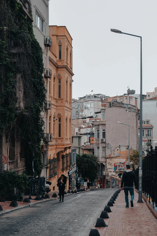 a group of people walking down a street next to tall buildings, a picture, pexels contest winner, renaissance, turkey, built on a steep hill, gif, background image