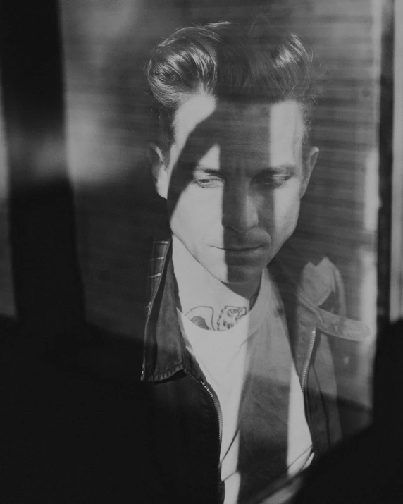 a black and white photo of a man in a suit, a black and white photo, inspired by casey baugh, pexels contest winner, photorealism, rockabilly hair, looking through frosted glass, in an old 1950s leather jacket, colin farrell