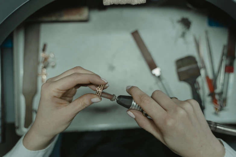 a close up of a person holding a pair of scissors, an engraving, trending on pexels, copper and emerald inlay, small manufacture, thumbnail, jewellery