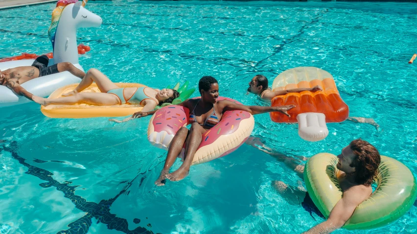 a group of people floating in a swimming pool, maria borges, pool tubes, thumbnail, bay area