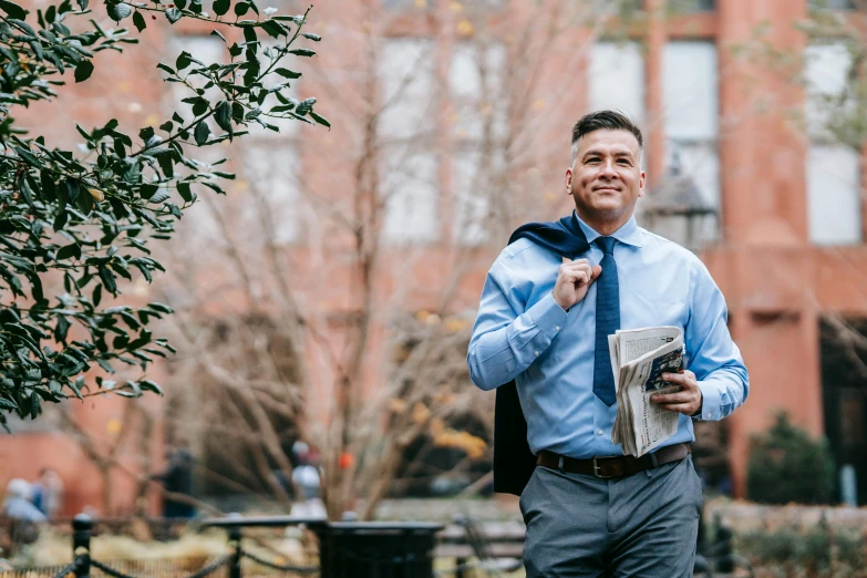 a man in a blue shirt and tie holding a newspaper, a photo, by Matt Cavotta, pexels contest winner, renaissance, outdoors business portrait, thumbnail, humans of new york style, slightly muscular