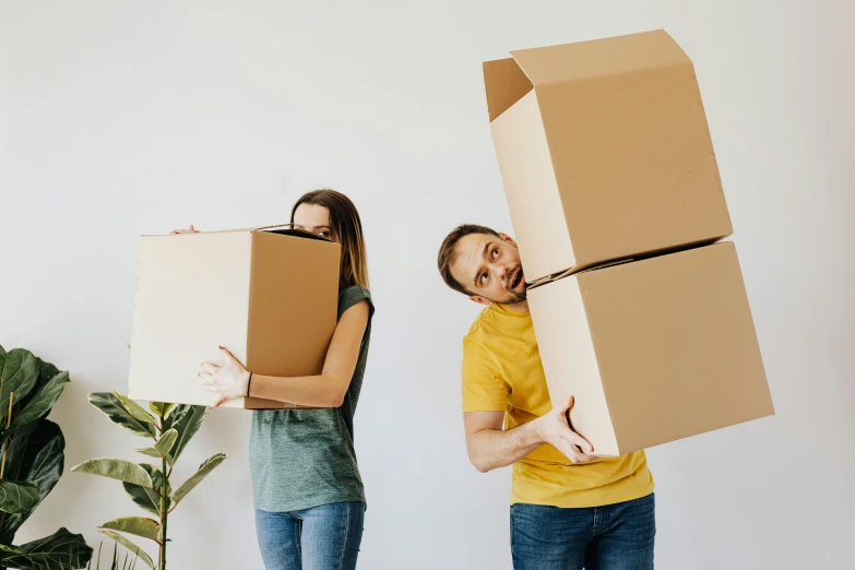 a man and a woman carrying boxes on their heads, a cartoon, pexels contest winner, australian, semi realistic, square, home