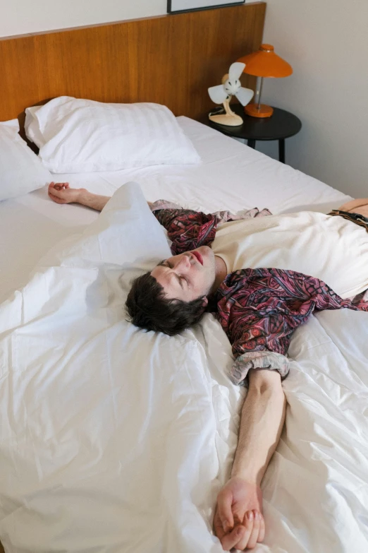 a couple of people laying on top of a bed, non binary model, sophia lillis, hotel room, siamese twins