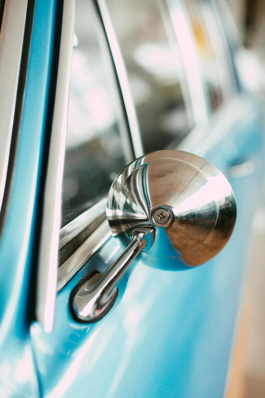 a close up of a car's side view mirror, by Sven Erixson, unsplash, photorealism, blue and silver, restomod, multiple stories, a high angle shot