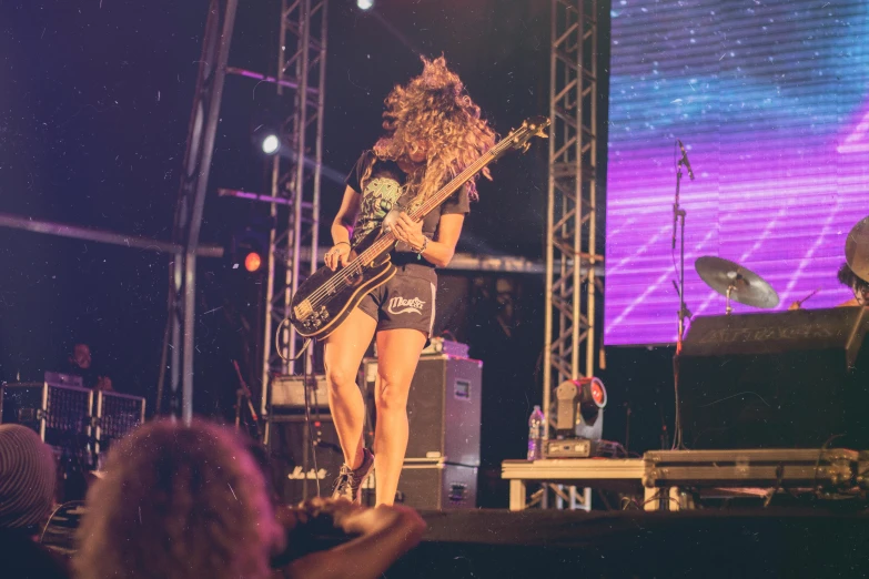 a woman that is standing on a stage with a guitar, pexels contest winner, happening, warped, twiddle, leg and thigh shot, islandpunk