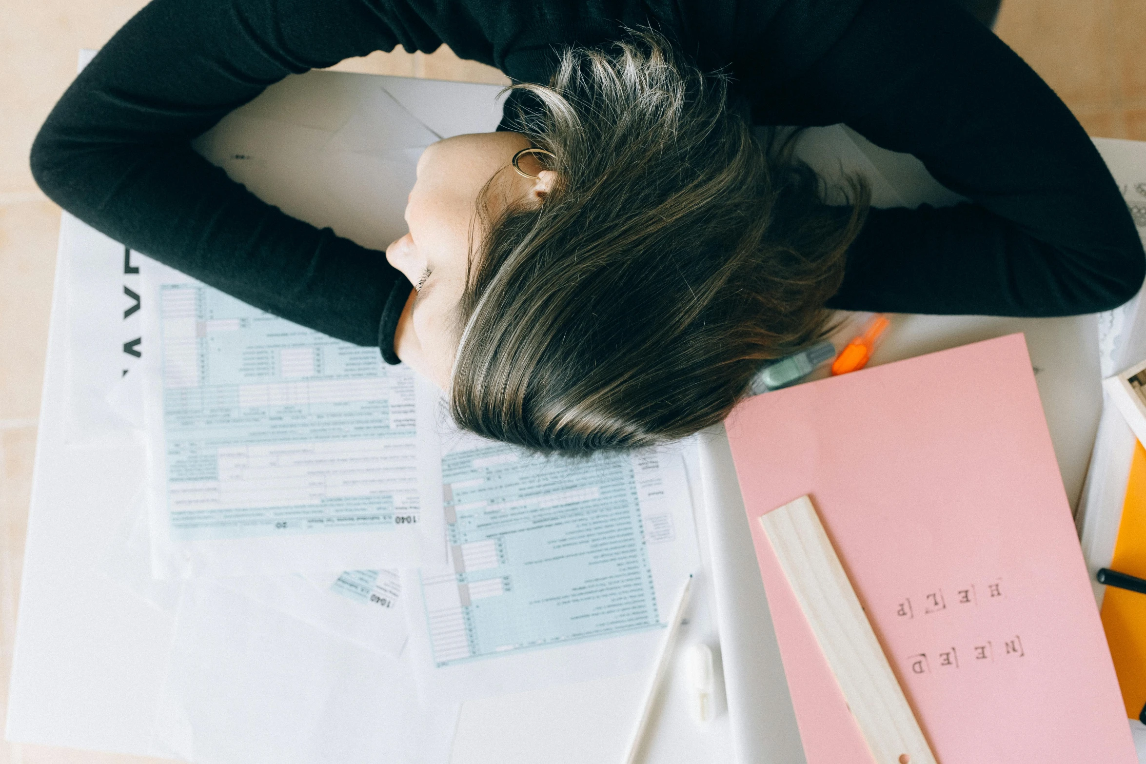 a woman laying on top of a table covered in papers, trending on pexels, worksafe. instagram photo, upsidedown, school curriculum expert, background image