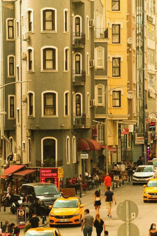 a busy city street filled with lots of traffic, a photo, inspired by Nadim Karam, art nouveau, bay area, tenement buildings, color”