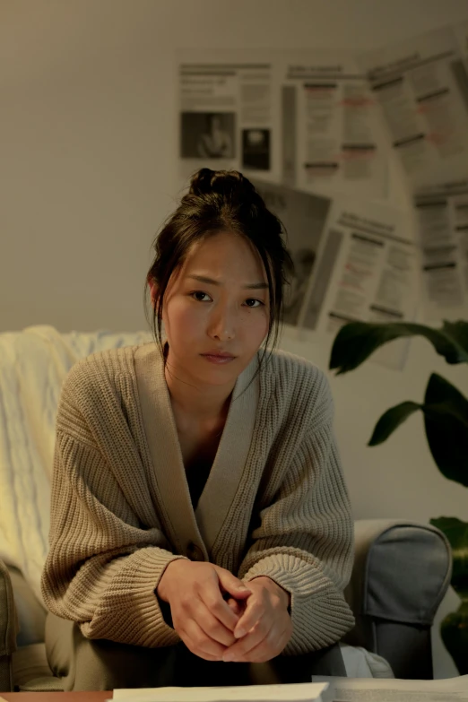 a woman sitting on a couch in a living room, inspired by Kim Tschang Yeul, unsplash, hyperrealism, low quality photo, soft lights, cardigan, still from a live action movie