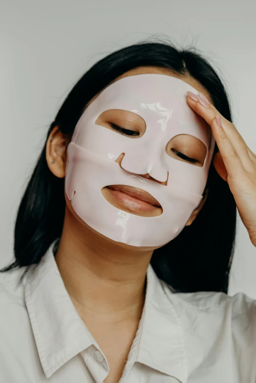 a woman putting a mask on her face, wide forehead, face and body clearly visible, silicone skin, slightly smiling