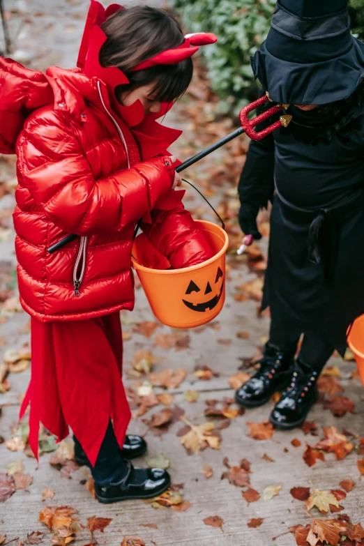 two little girls dressed up in halloween costumes, by Nina Hamnett, pexels, red lanterns, holding a crowbar, gif, orange jacket