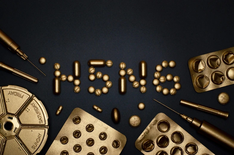 a bunch of gold pills sitting on top of a table, by Gavin Nolan, trending on unsplash, synthetism, coin with the letter n, chocolate. intricate background, realism : 9 5 %, stranger things vecna