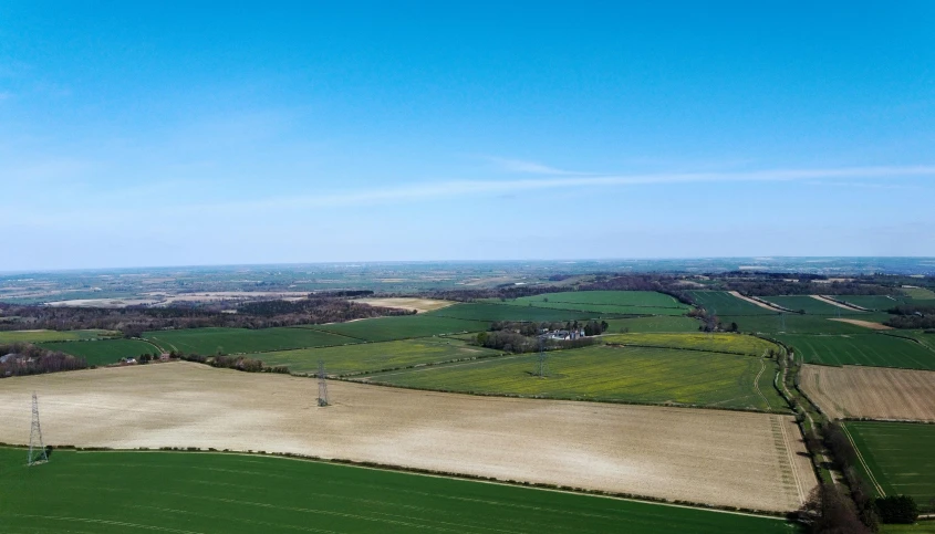 an aerial view of a field of crops, by Julian Allen, pexels contest winner, clear skies in the distance, madgwick, as an air balloon, panorama distant view