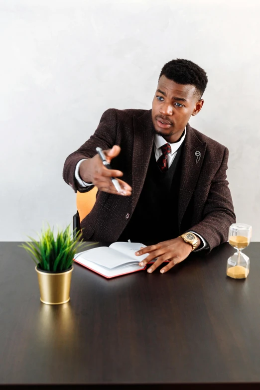 a man in a suit sitting at a table, pexels contest winner, black teenage boy, convincing, librarian, with a drink